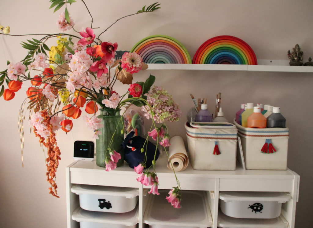 Kast met knutselspullen, verf en houten regenbogen in de opvangruimte